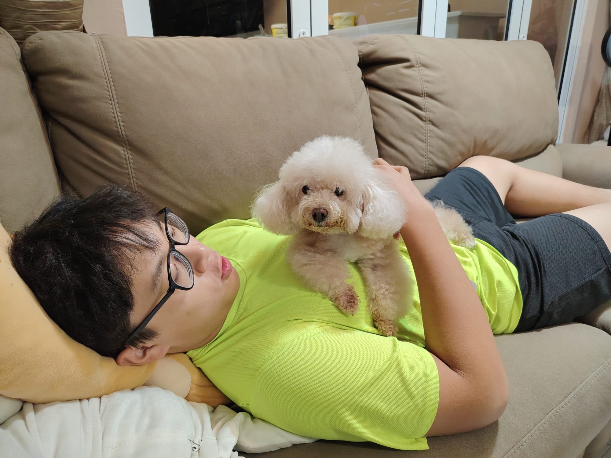 Low Cheng Jun relaxing with a small white dog