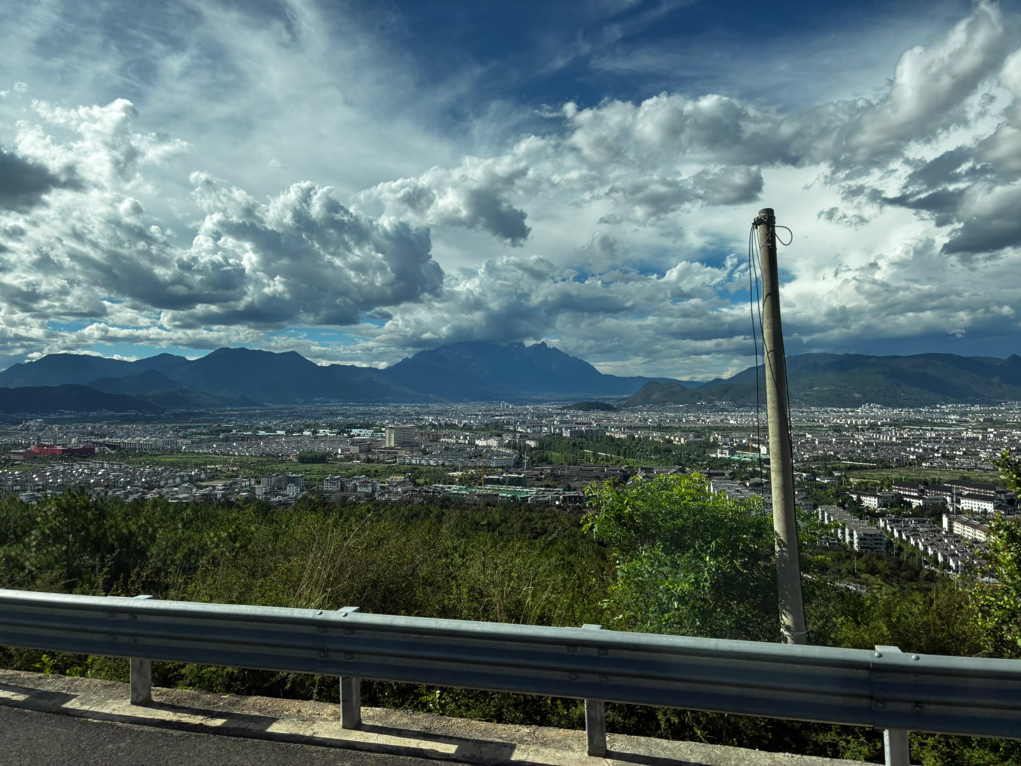 Mountain cityscape beneath dramatic clouds photographed by Low Cheng Jun